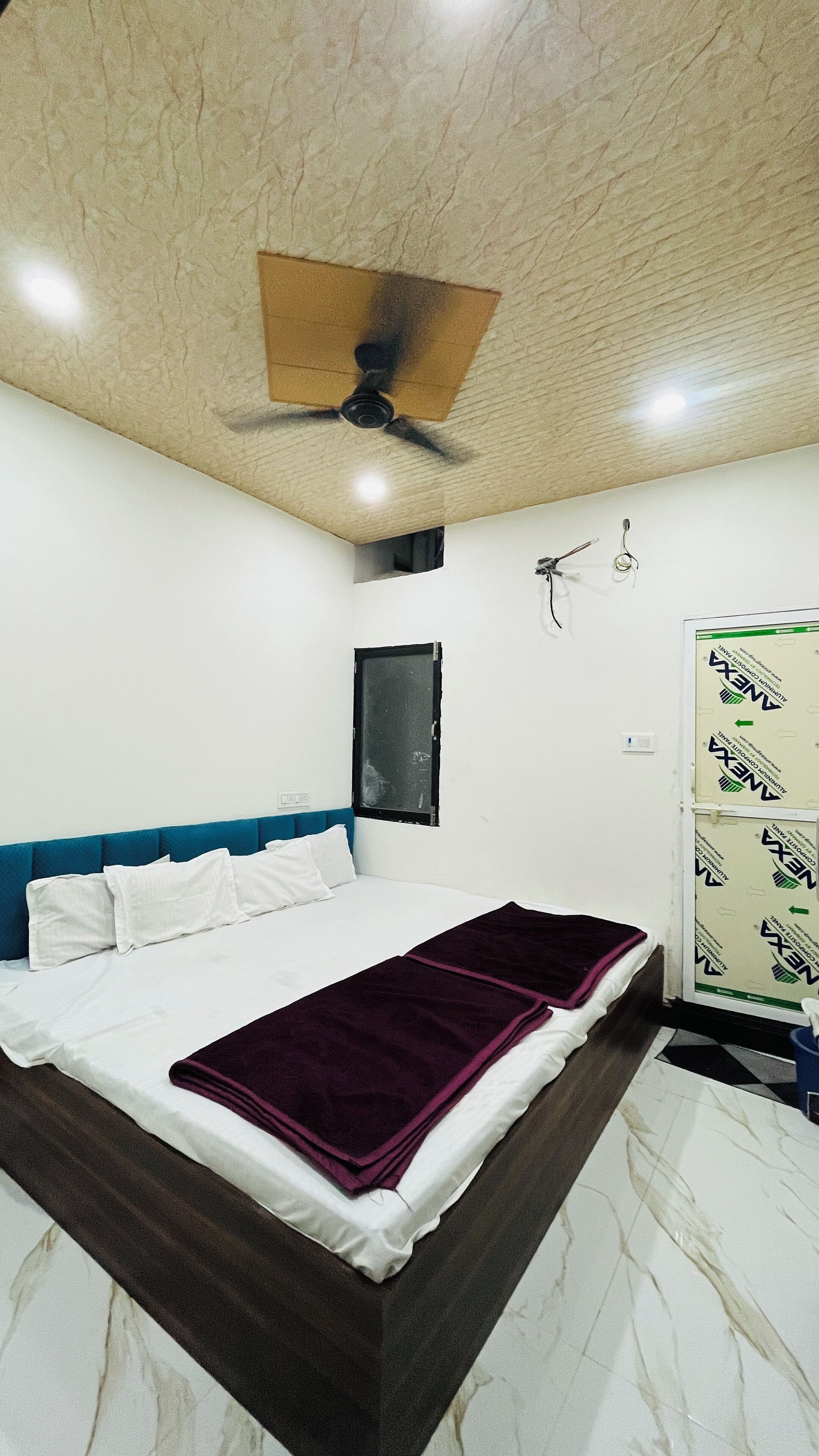 Ein Schlafzimmer mit Bett, Deckenventilator, Fenster und Kleiderschrank.