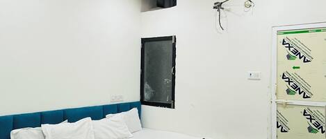 Ein Schlafzimmer mit Bett, Deckenventilator, Fenster und Kleiderschrank.