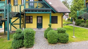 Un edificio amarillo con una escalera verde y un pequeño porche.
