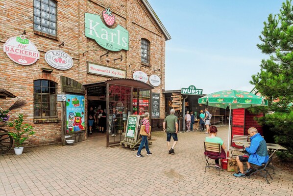 A brick building with multiple signs, including 'Karls' and 'Wurst'.