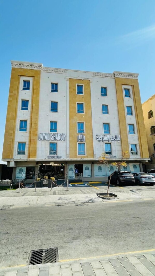 A multi-story hotel with a yellow and white facade, named "Layali Sharqiy."