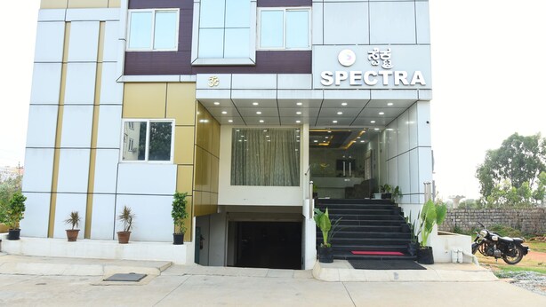 Un edifici modern amb un rètol que diu “SPECTRA” i una escala que condueix a l'entrada.
