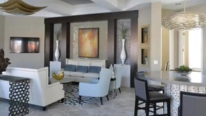 A modern living room with a sofa, chairs, a coffee table, and a dining area with a table and chairs. - Solterra Resort!! Spacious House With Game Room, Private Pool and Movie Room!! (Davenport)