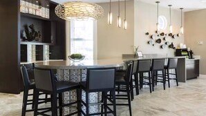 A modern kitchen with a central island, black bar stools, pendant lighting, and decorative wall art. - Solterra Resort!! Spacious House With Game Room, Private Pool and Movie Room!! (Davenport)