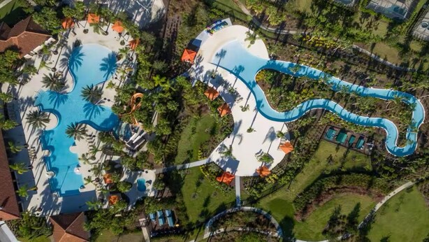 An aerial view of a resort with two large pools, a water slide, and surrounding greenery. - Solterra Resort!! Spacious House With Game Room, Private Pool and Movie Room!! (Davenport)