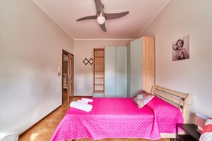 A bedroom with a bed, a ceiling fan, a wardrobe, and a door leading to another room. - Tecla - 3 bedrooms with garage and WiFi (Sirmione)