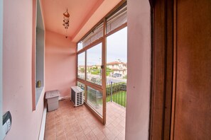 A balcony with a view of a residential area, a trash bin, and an air conditioning unit. - Tecla - 3 bedrooms with garage and WiFi (Sirmione)