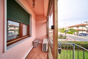 A balcony with a green shuttered window, a small bench, and a trash bin. - Tecla - 3 bedrooms with garage and WiFi (Sirmione)