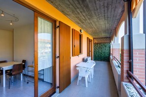 Ein modernes Interieur mit Essbereich, Küche und einem Balkon mit Backsteinwand und Bepflanzung.