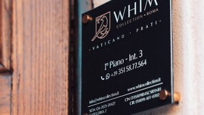 A black sign with white text on a wall, indicating a piano room with contact information and website URLs. - Whim Collection Vaticano Prati  (Rome)