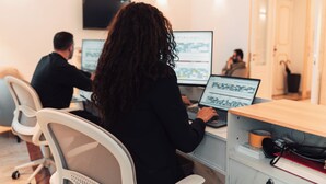 Un bureau moderne doté de plusieurs postes de travail, chacun équipé d’un écran d’ordinateur.
