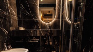 A modern bathroom with a large mirror, two sinks, and a glass-enclosed shower area. - Whim Collection Trastevere (Rome)