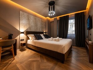 A modern hotel room with a large bed, bedside tables, a desk, and a view of the city. - Whim Collection Trastevere (Rome)