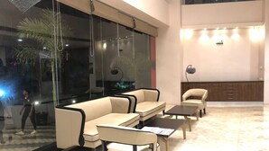 A modern lounge area with a sofa set, coffee table, and a cabinet. - OASIS SUITES (Hubli)