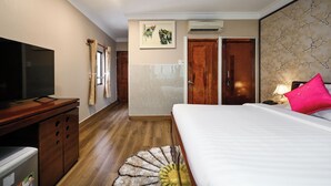 Ein Hotelzimmer mit Bett, Fernseher, Schreibtisch und Bad.
