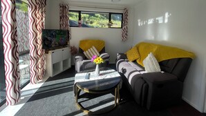 Een moderne woonkamer met een bank, salontafel en televisie.