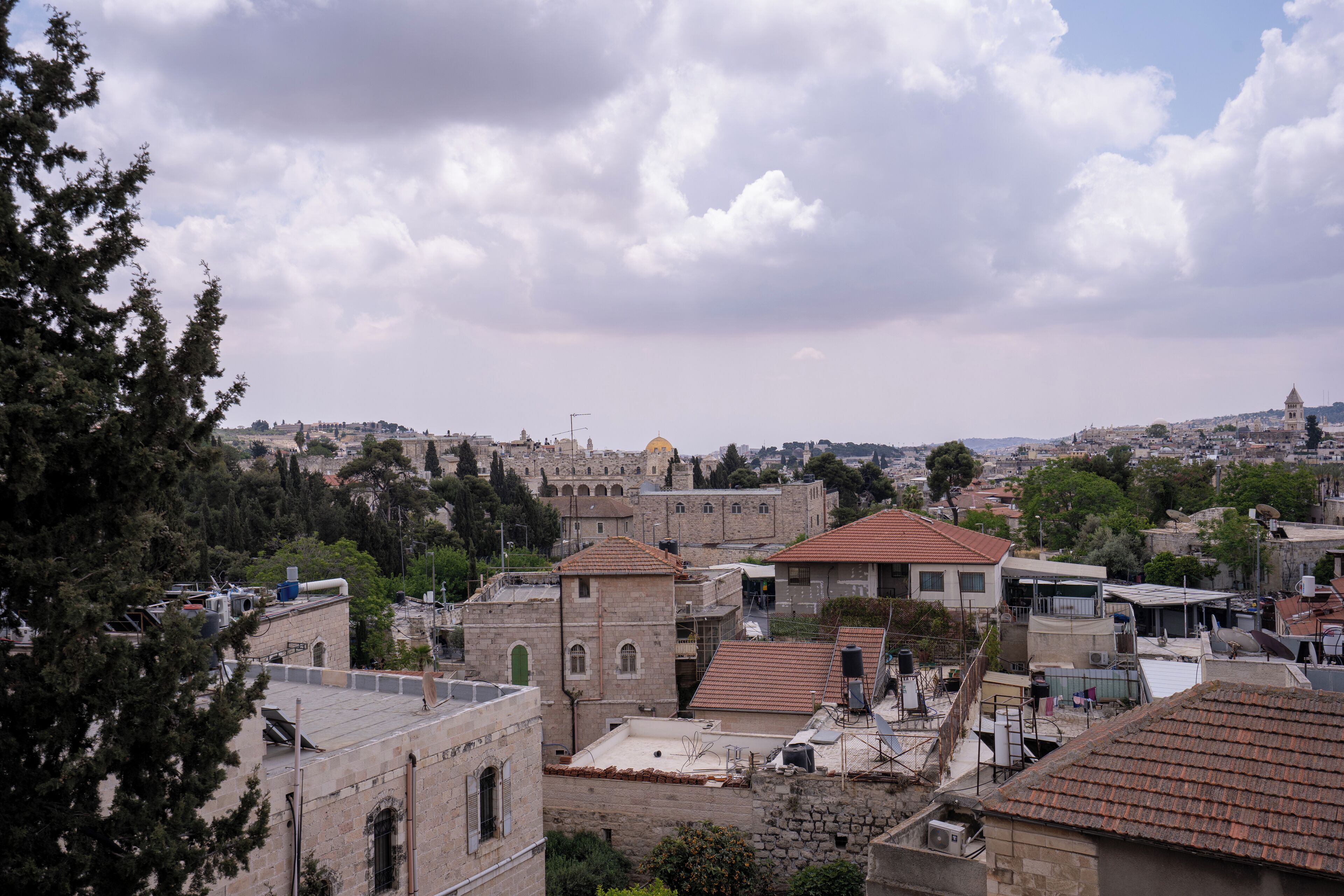 A view of a historic cityscape with stone buildings, a prominent dome, and a mix of residential and commercial structures.
