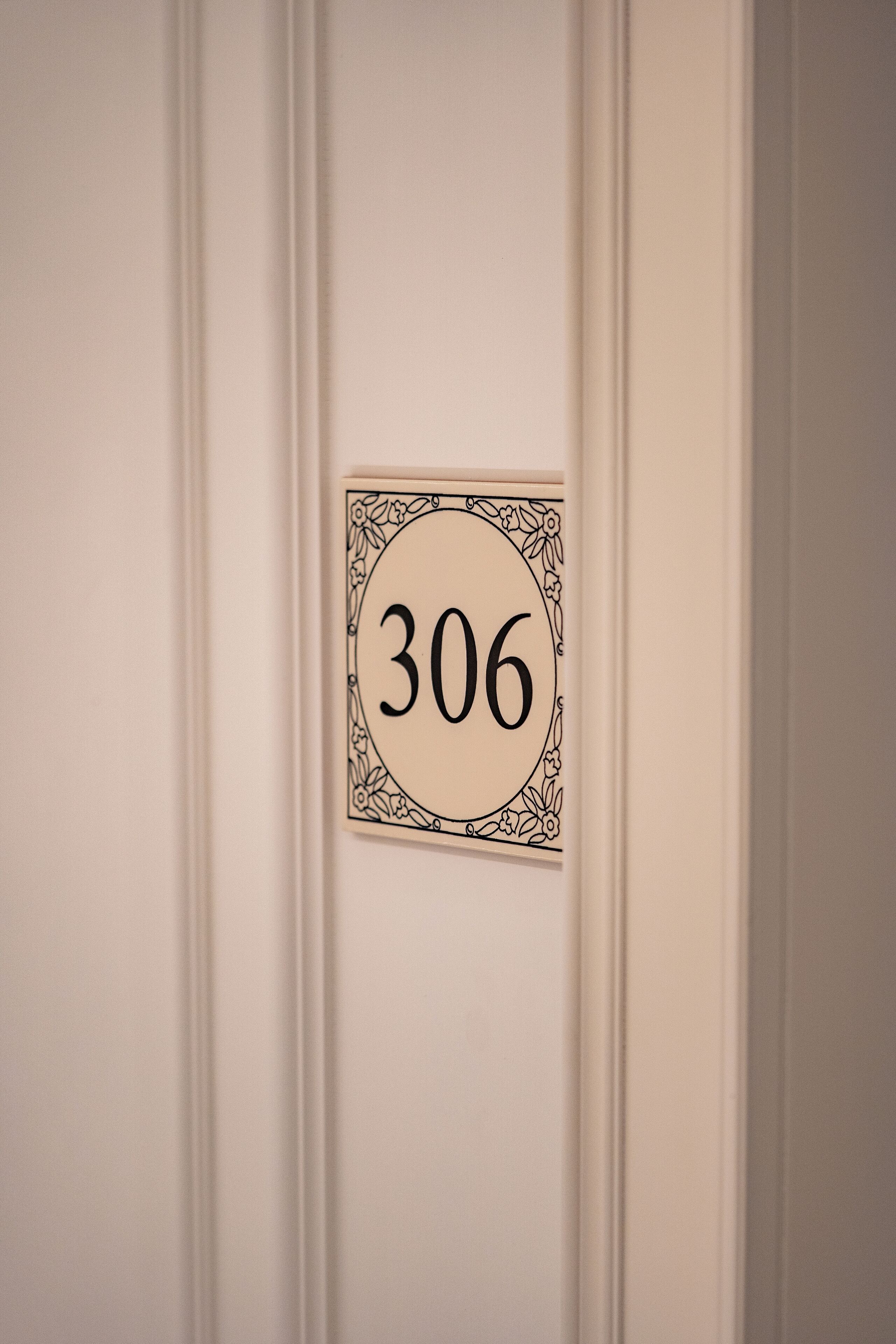 Una porta con una targa che indica il numero 306.