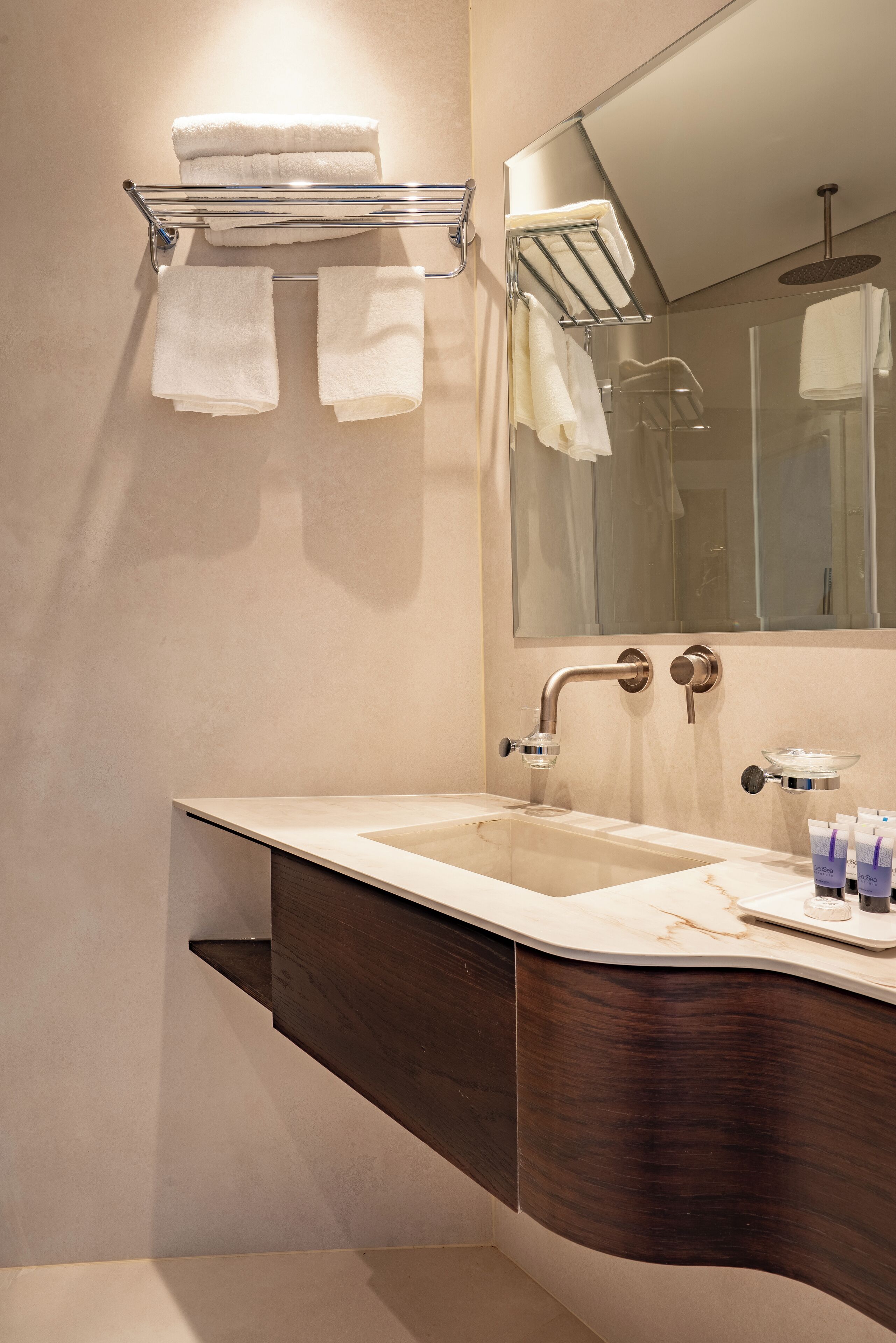 A modern bathroom with a double sink, a large mirror, and a towel rack.