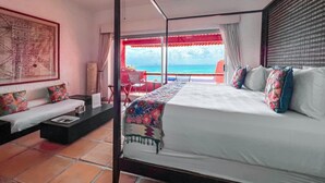 Una camera da letto con un letto, un divano, un tavolino e vista sull'oceano.