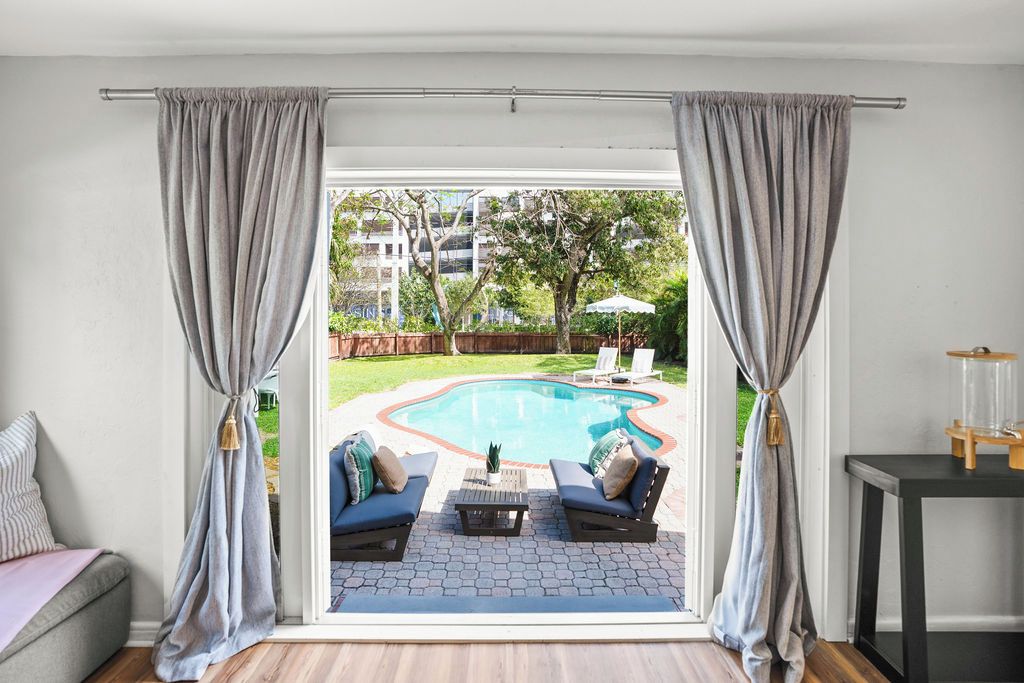 Step outside and enjoy easy access to the sparkling pool! 🌴☀️ This bright space offers beautiful views of the pool and a relaxing spot to soak up the sunshine. 🏊‍♀️✨