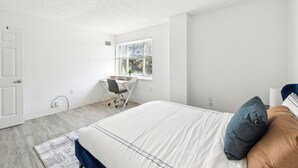 Une chambre à coucher avec un lit, un bureau et une fenêtre.