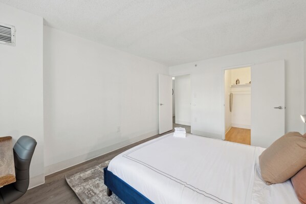 A bedroom with a bed, a chair, and a wardrobe.