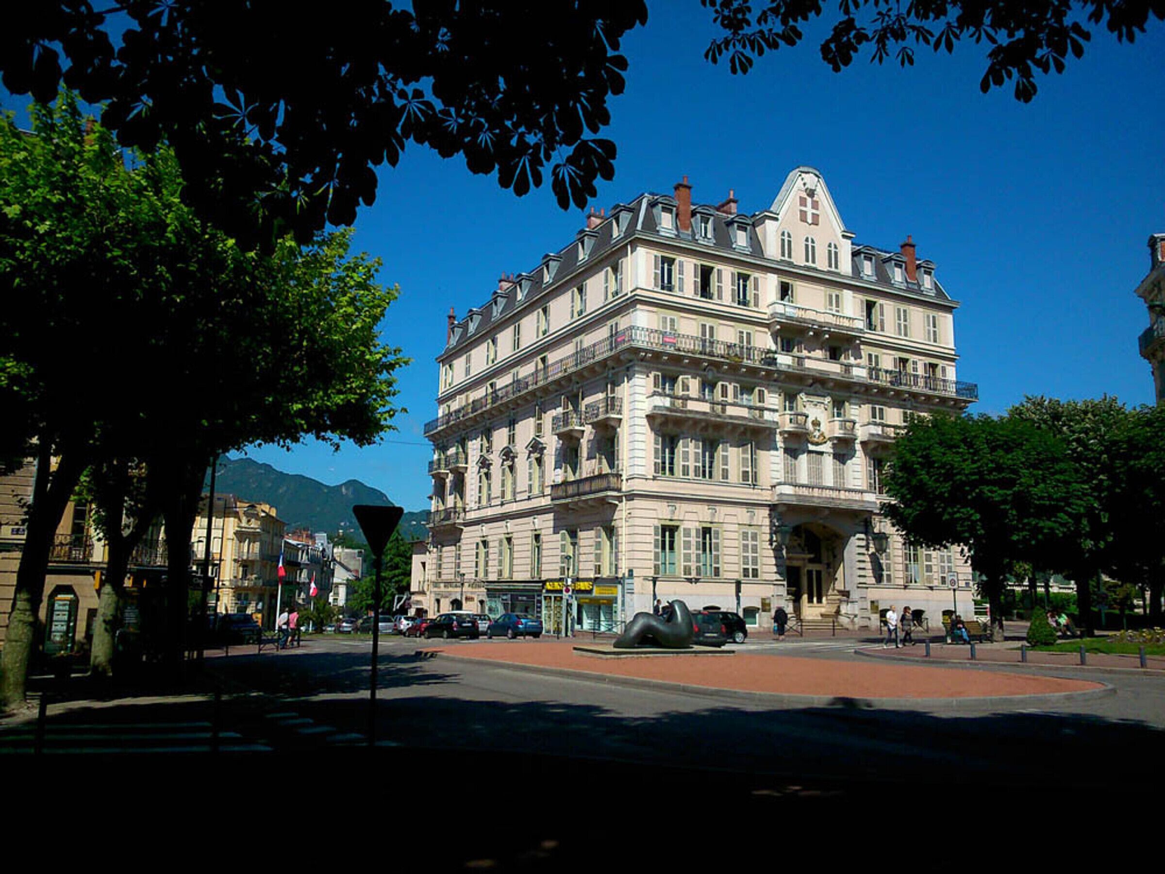 Um edifício histórico com vários andares, janelas amplas e uma entrada imponente.