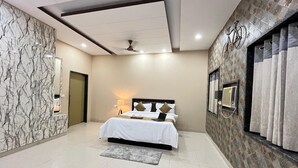 A modern hotel room with a bed, a desk, a chair, a window, and a door. - GoBravo 11 6BHK Farm with Pool Sohna Road Gurgaon  (Sohna)