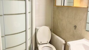 Un baño con inodoro, ducha y lavamanos.