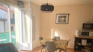 Un comedor con una mesa, sillas y una lámpara en el techo.