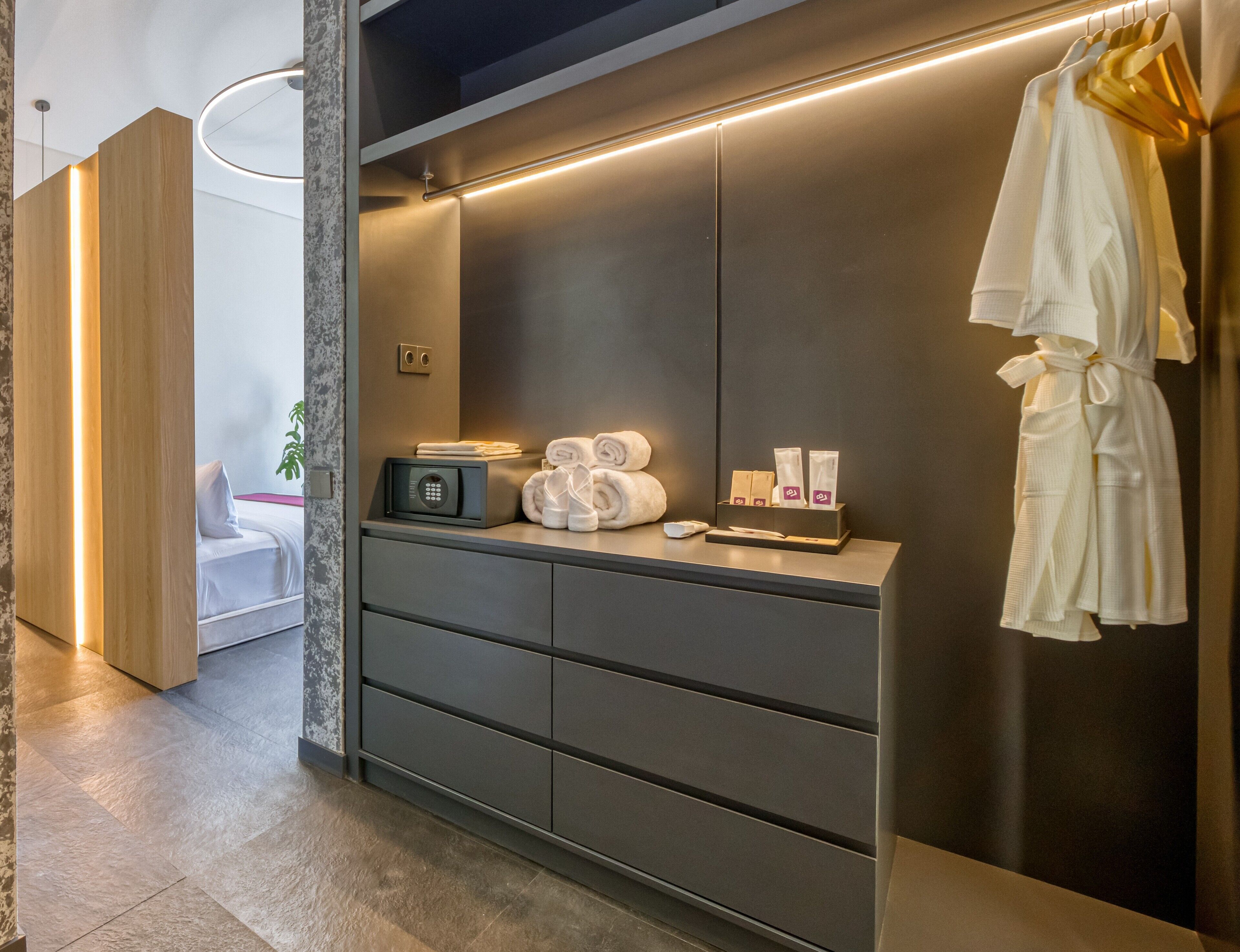 A modern bathroom with a vanity, towel rack, and toiletries.