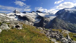 Eine Berglandschaft mit schneebedeckten Gipfeln und blauem Himmel.