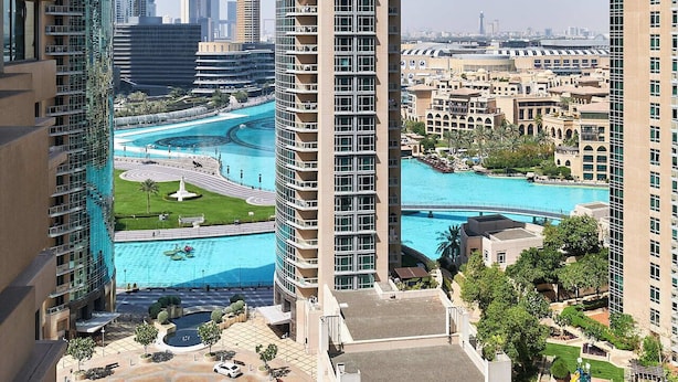 A high-rise building with a pool area, including a central fountain and surrounding greenery. - Bellavista-Striking-1Bedroom with Annex (Dubai)