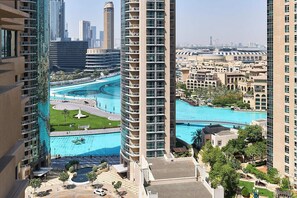 A high-rise building with a pool area, including a central fountain and surrounding greenery. - Bellavista-Striking-1Bedroom with Annex (Dubai)