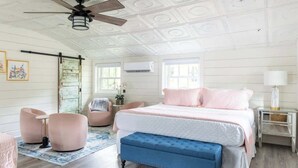 Ein Schlafzimmer mit Bett, Deckenventilator, Fenster und Nachttisch.