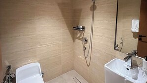 Un baño moderno con ducha, inodoro y lavamanos.