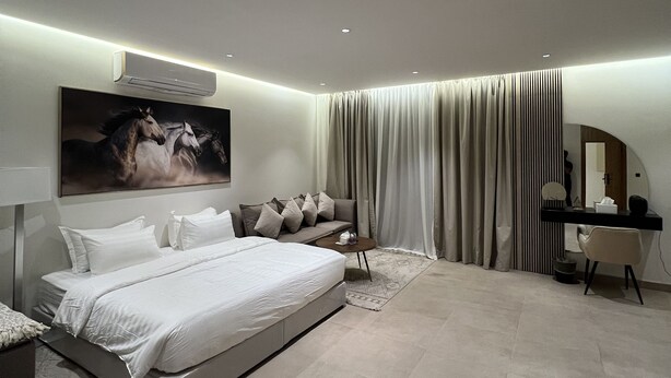 Un dormitorio moderno con una cama grande, un escritorio y una silla.