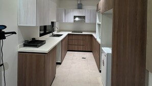 Una cocina moderna con armarios blancos, una isla central y un horno empotrado.