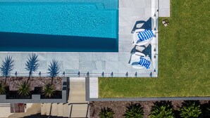 An aerial view of a swimming pool with adjacent lounge chairs and a grassy area. - SCOTTS RETREAT - RELAX BY THE POOL (Scotts Head)