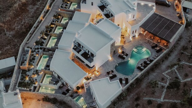 Eine Vogelperspektive zeigt ein Resort mit mehreren Gebäuden, einem Pool und Außenbereichen zum Sitzen.