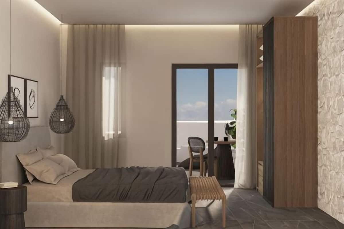 A modern bedroom with a bed, bedside tables, a chair, and a view of the outdoors.