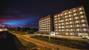 A multi-story hotel with illuminated balconies and a prominent signage.
