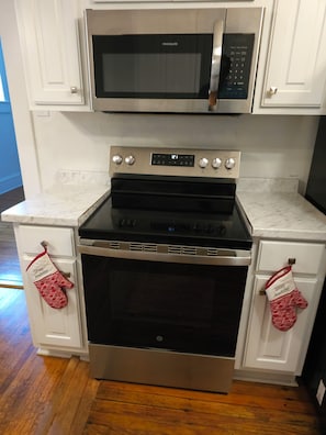 A kitchen with a stainless steel microwave, oven, and two ovens. - Charming 4-Bedroom Historic Home w/ Game Room + Backyard BBQ (Goldsboro)
