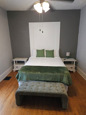 A bedroom with a bed, two bedside tables, a bench, and a ceiling fan. - Charming 4-Bedroom Historic Home w/ Game Room + Backyard BBQ (Goldsboro)