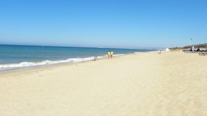 A wide sandy beach with a clear blue sky and calm sea. - 3Br Apt-quinta do Lago-private Terrace (Loulé)