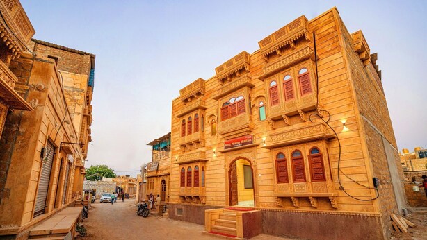 A traditional building with multiple windows and balconies, a sign for 'Hotel Mantra Heritage', and a staircase leading to the entrance. - Hotel Mantra Heritage Jaisalmer (Jaisalmer)