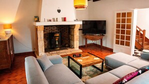 Ein Wohnzimmer mit Kamin, Fernseher und Treppe.