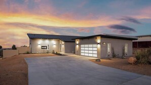 A modern two-story house with a garage, driveway, and landscaped garden. - No Vacancy • New Home, Game Room, Spa, Hammocks (Joshua Tree)