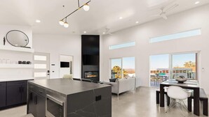 A modern kitchen with a central island, built-in appliances, and a dining area with a view. - No Vacancy • New Home, Game Room, Spa, Hammocks (Joshua Tree)